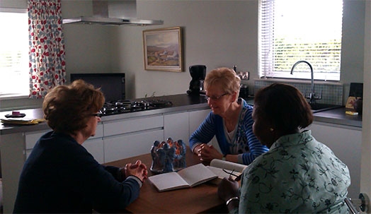 A group praying around a kitchen table