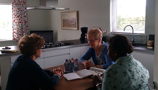 A group praying around a kitchen table